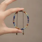 Bracelet 7 chakras femme tenu en main, les sept couleurs visibles