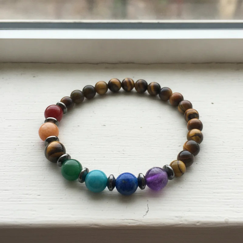 Bracelet 7 chakras oeil de tigre près d'une fenêtre