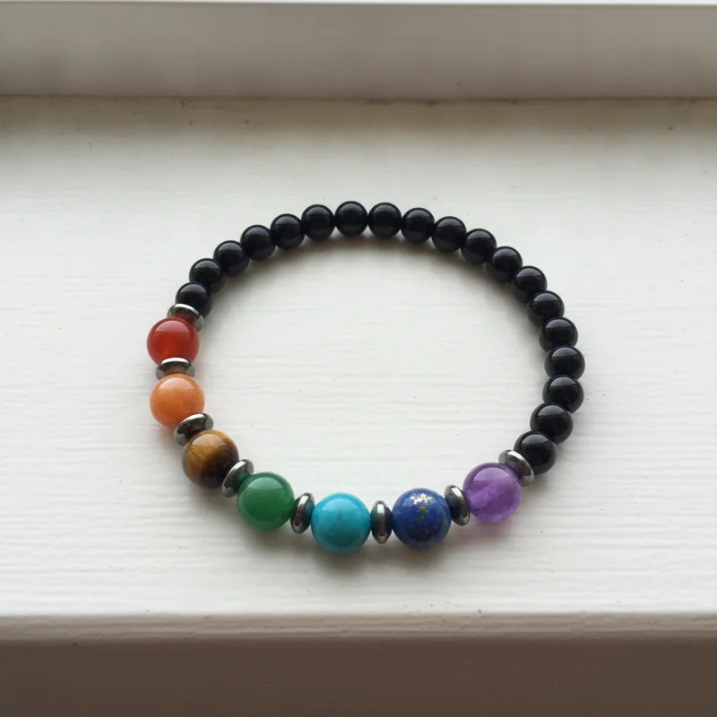 Bracelet 7 chakras onyx près d'une fenêtre