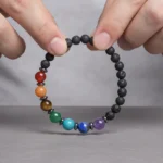 7-chakras-pierre-de-lave-main-ouvert Bracelet 7 chakras pierre de lave tenu en main, les sept perles visibles