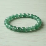 Bracelet aventurine verte de trois quarts sur bois clair