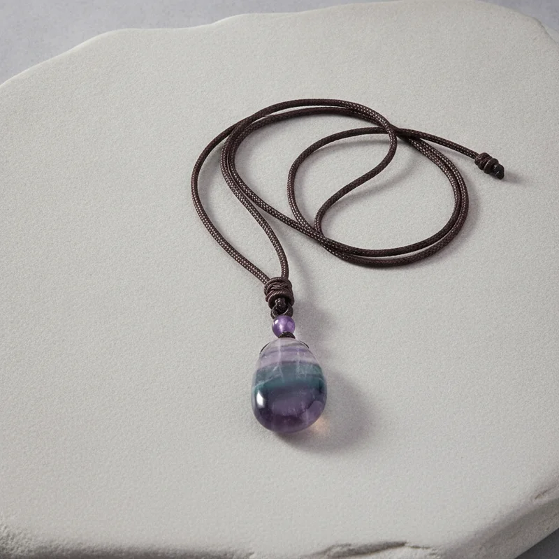 Pendentif fluorite posé sur pierre claire