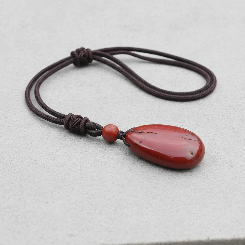 Pendentif jaspe rouge posé sur pierre claire