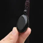 obsidienne-main Goutte d'obsidienne noire tenue en main