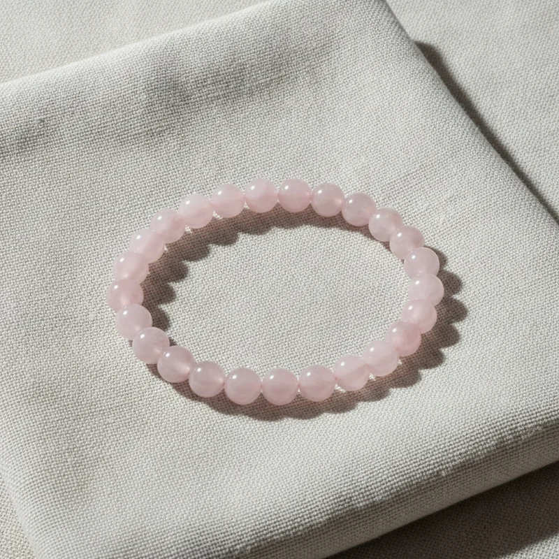 Bracelet quartz rose posé sur du lin clair