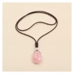 Pendentif quartz rose posé à plat sur fond clair