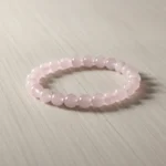 Bracelet quartz rose de trois quarts sur bois clair