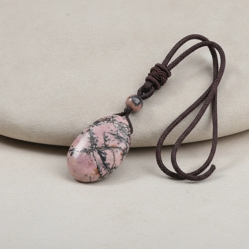 Pendentif rhodochrosite posé sur pierre claire
