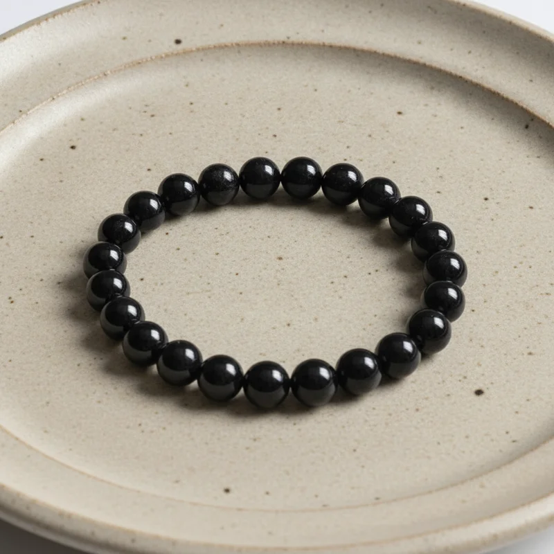 Bracelet tourmaline noire posé à plat sur une assiette claire
