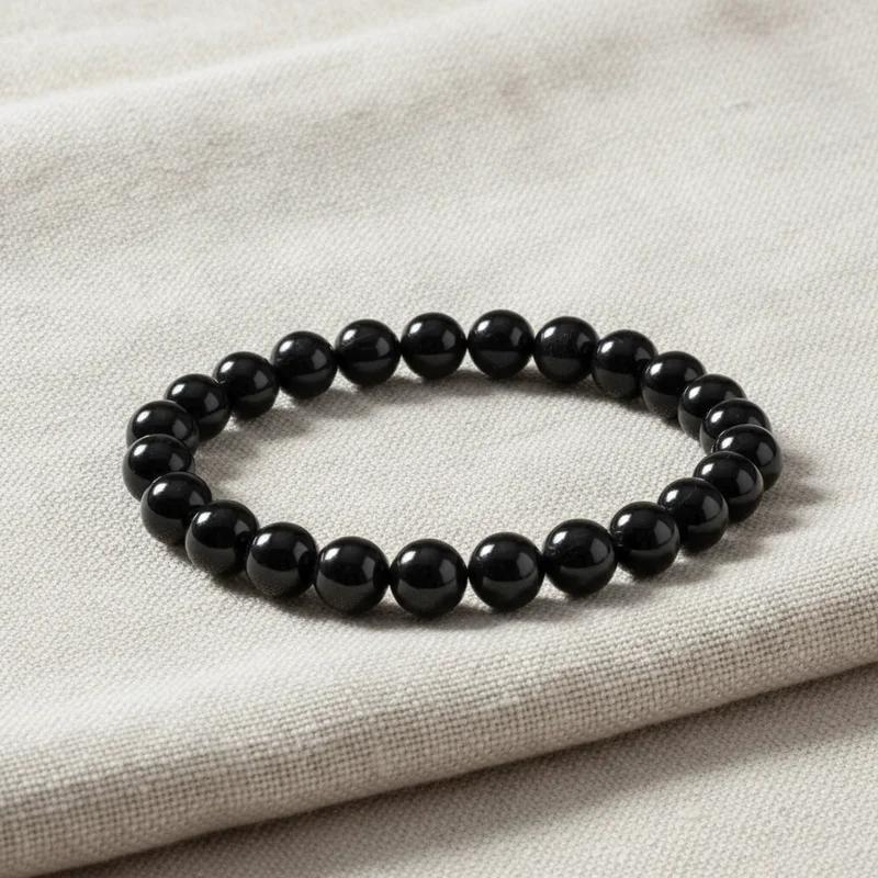 Bracelet tourmaline noire posé sur du lin clair