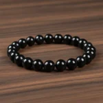 Bracelet tourmaline noire de trois quarts sur bois foncé