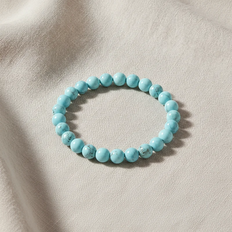 Bracelet turquoise posé sur du lin clair