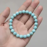 Bracelet turquoise tenu dans une main